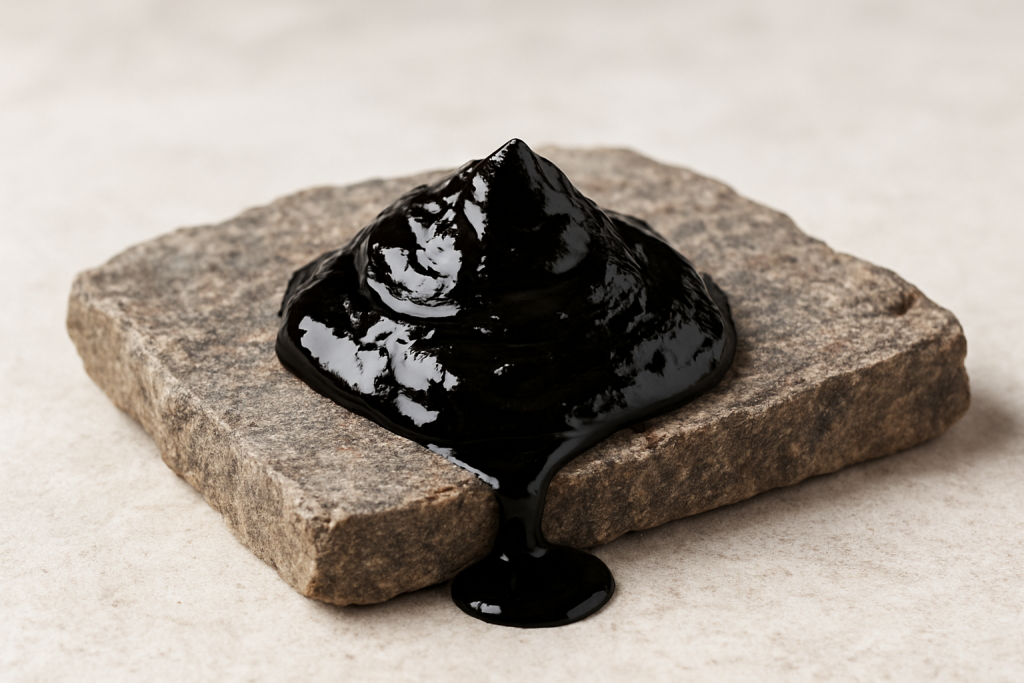 Close-up of black shilajit paste on a stone slab